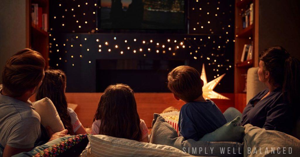 A family watching a New Year's Eve Movie for kids together.