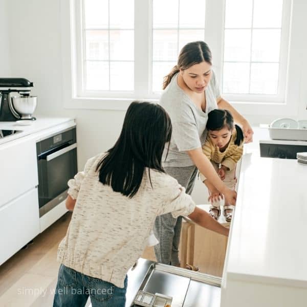 Kids helping mom put dishes in the dishwasher.