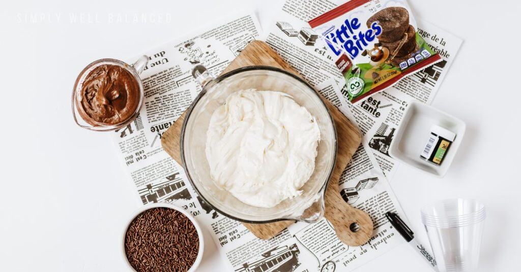 Easy Frankenstein dessert cup ingredients: Philadelphia Cheesecake filling, lil bites brownies, chococalte frosting, sprinkles, food coloring, cool whip. 