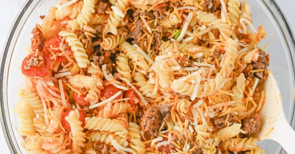 Doritos taco pasta salad being mixed in a bowl