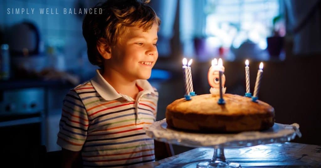 Young boy celebrating a no party birthday at home. Blowing out his candles on his cake.