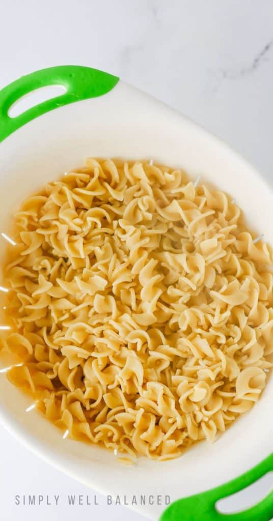 Egg noodles cooked and drained in a collander.