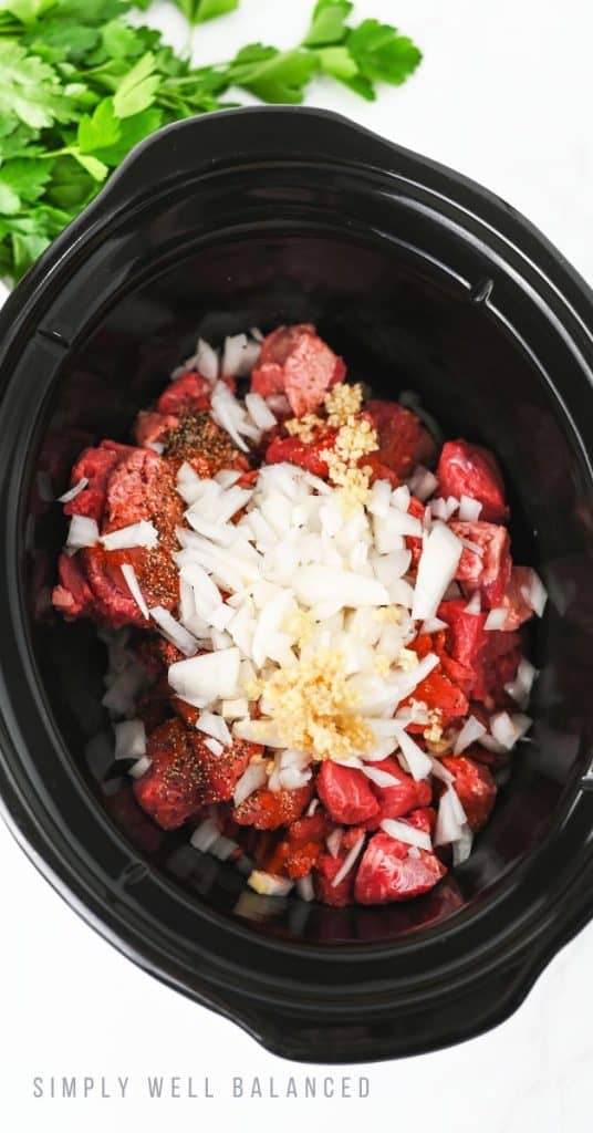 Slow Cooker Beef Stroganoff Recipe Step 1: Stew meat, spices, onion and garlic are loaded into the slow cooker.